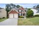 Charming two-story brick home boasts a well-maintained lawn and attached two-car garage at 5312 Tormeal Trce, Suwanee, GA 30024