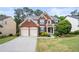 Traditional two-story brick home with a two-car garage, manicured lawn, and mature shrubs at 5312 Tormeal Trce, Suwanee, GA 30024