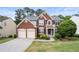 Traditional brick home with a manicured lawn, blue shutters, and a welcoming front entrance at 5312 Tormeal Trce, Suwanee, GA 30024