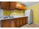 This kitchen area features wooden cabinets, a stainless steel sink, and a refrigerator at 5312 Tormeal Trce, Suwanee, GA 30024
