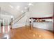 Bright, open-concept space features hardwood floors, a staircase, and view of the kitchen area at 5312 Tormeal Trce, Suwanee, GA 30024