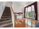 Spacious living room with hardwood floors, staircase, and tall windows offering plenty of natural light at 5312 Tormeal Trce, Suwanee, GA 30024