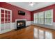 Cozy living room with hardwood floors, fireplace, french door, and multiple windows at 5312 Tormeal Trce, Suwanee, GA 30024