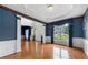 Bright living room with hardwood floors, wainscoting, and large windows with elegant drapery at 5312 Tormeal Trce, Suwanee, GA 30024