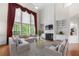 Cozy living room with a fireplace, built-in shelving, and large windows with decorative drapes at 5312 Tormeal Trce, Suwanee, GA 30024