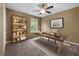 Comfortable office with ceiling fan, built-in shelves, a modern desk, and a neutral color scheme at 5312 Tormeal Trce, Suwanee, GA 30024