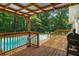 Open back deck with access to a pristine in-ground swimming pool surrounded by lush greenery at 5401 Rosser Rd, Tucker, GA 30087