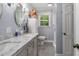 Bathroom featuring a double sink, marble countertops, and a window with natural light at 5401 Rosser Rd, Tucker, GA 30087