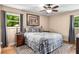 This cozy bedroom features a ceiling fan, a queen bed with decorative bedding, and a large window at 5401 Rosser Rd, Tucker, GA 30087