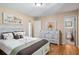 This bedroom features a light colored hardwood floor, a dresser and an en suite bathroom at 5401 Rosser Rd, Tucker, GA 30087