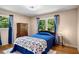 This bedroom has two windows, hardwood floors, blue bedspread, and a wooden dresser at 5401 Rosser Rd, Tucker, GA 30087
