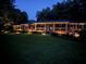 Beautifully lit home at night with a well-kept lawn, inviting porch, and lush surrounding trees at 5401 Rosser Rd, Tucker, GA 30087