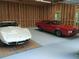 Spacious garage featuring a white Corvette and red GTO parked on a newly-sealed light gray floor at 5401 Rosser Rd, Tucker, GA 30087
