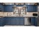This kitchen features blue cabinetry, stainless steel appliances, and light granite countertops at 5401 Rosser Rd, Tucker, GA 30087