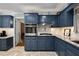 This kitchen features stainless appliances, tiled backsplash, blue cabinets and granite countertops at 5401 Rosser Rd, Tucker, GA 30087
