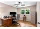 Bright office space with hardwood floors, large window, desk setup with monitors, and file cabinets at 5401 Rosser Rd, Tucker, GA 30087