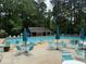 Community pool with lounge chairs, tables, umbrellas, and a bath house at 5401 Rosser Rd, Tucker, GA 30087