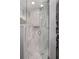A glass-enclosed shower with marble tiling, a built-in niche, and modern fixtures at 5401 Rosser Rd, Tucker, GA 30087