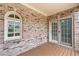 A charming balcony featuring brick accents, wood flooring, and a sliding glass door entrance at 611 Parkside Village Nw Way, Marietta, GA 30060