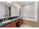 Bathroom featuring double sinks with granite countertop, a built-in tub, and tiled flooring at 611 Parkside Village Nw Way, Marietta, GA 30060