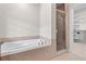 A luxurious soaking tub next to a glass door shower, adjacent to a walk-in closet at 611 Parkside Village Nw Way, Marietta, GA 30060