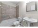 Bathroom featuring neutral tile surround on a tub with shower combo and single sink vanity at 611 Parkside Village Nw Way, Marietta, GA 30060