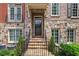 Inviting front entrance with stone and brick facade, complemented by lush greenery and a secure railing at 611 Parkside Village Nw Way, Marietta, GA 30060