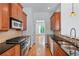 Galley kitchen featuring wood cabinets, granite countertops and stainless steel appliances at 611 Parkside Village Nw Way, Marietta, GA 30060