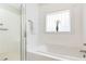 Bathroom showcasing a glass-enclosed shower and a separate soaking tub beneath a brick window at 2167 Tilson Rd, Decatur, GA 30032