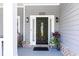 Inviting front door with sidelights and brick accents, enhanced by modern outdoor lighting, creates a warm and welcoming entry at 2167 Tilson Rd, Decatur, GA 30032