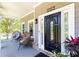Inviting front porch with a stylish black door, decorative plants, and charming brick accents at 2167 Tilson Rd, Decatur, GA 30032