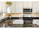 Well-lit kitchen featuring granite countertops, white cabinets, stainless steel appliances, and a stylish backsplash at 2167 Tilson Rd, Decatur, GA 30032