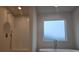 Modern bathroom featuring a walk-in shower, bathtub, and frosted window at 246 Crabapple Rd, Mcdonough, GA 30253