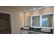 Bathroom vanity featuring double sinks, dark countertops, and lighted mirrors at 246 Crabapple Rd, Mcdonough, GA 30253