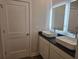 Stylish bathroom boasting dual vessel sinks, black granite countertop, and elegantly lit mirrors at 246 Crabapple Rd, Mcdonough, GA 30253