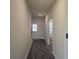 Hallway featuring dark wood flooring, leading to a door with light coming through at 246 Crabapple Rd, Mcdonough, GA 30253