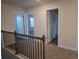 Upstairs hallway featuring neutral carpeting and two doors leading into adjacent rooms at 246 Crabapple Rd, Mcdonough, GA 30253