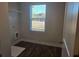Functional laundry room with window, wire shelving, and dark wood flooring at 246 Crabapple Rd, Mcdonough, GA 30253