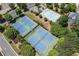 Aerial view of tennis courts and a community pool surrounded by lush greenery in the neighborhood at 3930 Suwanee Bend Dr, Suwanee, GA 30024
