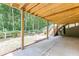 Covered outdoor area with stairs to the backyard, bordered by mature trees and wooden fence at 3930 Suwanee Bend Dr, Suwanee, GA 30024