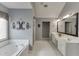 Bright bathroom featuring a soaking tub, double sink vanity, and tile flooring at 3930 Suwanee Bend Dr, Suwanee, GA 30024