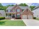 Charming two-story brick home with a well-manicured lawn and a welcoming front porch at 3930 Suwanee Bend Dr, Suwanee, GA 30024