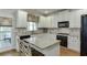 Kitchen boasts granite countertops, stainless appliances, white cabinets, and a center island at 3930 Suwanee Bend Dr, Suwanee, GA 30024