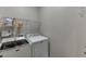 Laundry room with modern washer and dryer and wire rack shelving at 3930 Suwanee Bend Dr, Suwanee, GA 30024