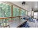 Spacious screened porch with dining and seating areas, offering views of the wooded backyard at 3930 Suwanee Bend Dr, Suwanee, GA 30024