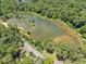 Scenic aerial view showing the lake surrounded by lush foliage, offering a tranquil and picturesque setting at 4624 Park Dr, Pine Lake, GA 30072