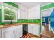 Charming kitchen featuring white cabinets, a wood countertop, copper sink, and bright green walls at 4624 Park Dr, Pine Lake, GA 30072