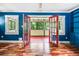 Living room with blue walls, hardwood floors, red french doors and built-in shelving at 4624 Park Dr, Pine Lake, GA 30072