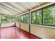 Bright sunroom featuring large windows with lush green backyard views and wood paneled walls at 4624 Park Dr, Pine Lake, GA 30072