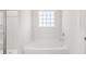 Well-lit bathroom showcasing a soaking tub and glass-enclosed shower with tiled surround at 6131 Knickerbocker St, Mableton, GA 30126